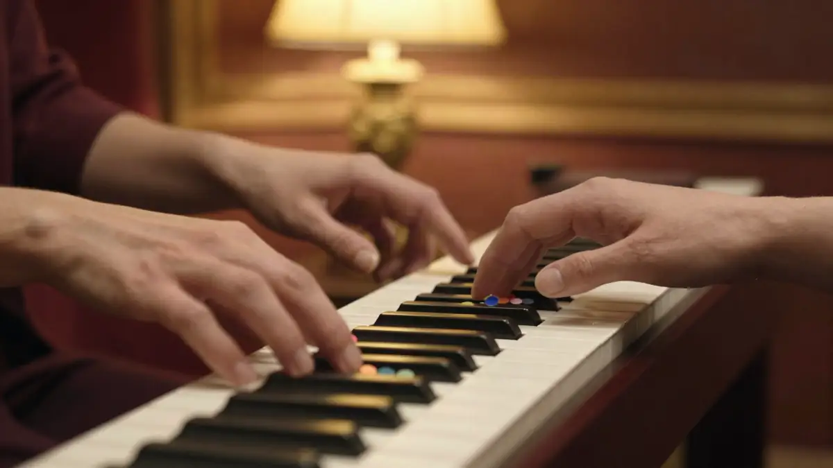 Hands playing C, F and G chords on a piano keyboard