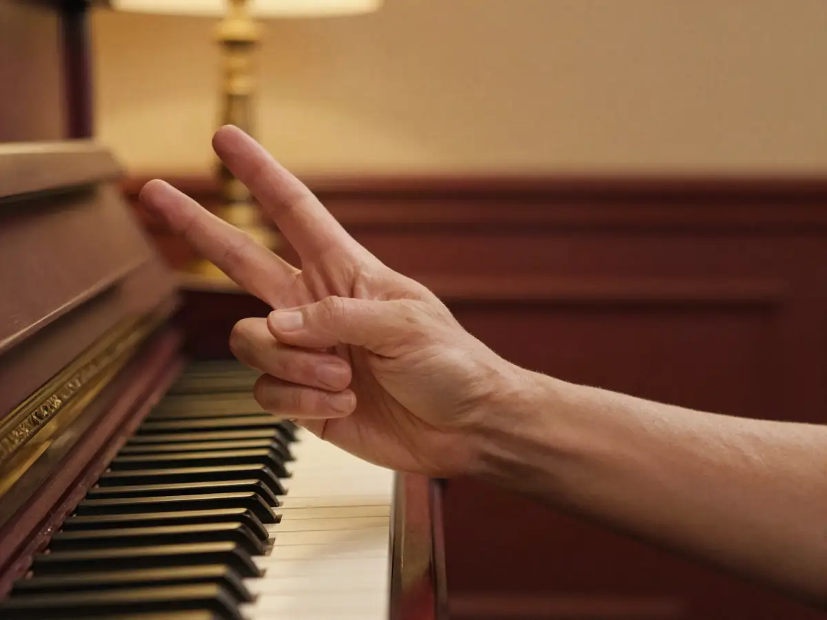 A right hand playing a three-note chord with thumb, middle finger and pinky