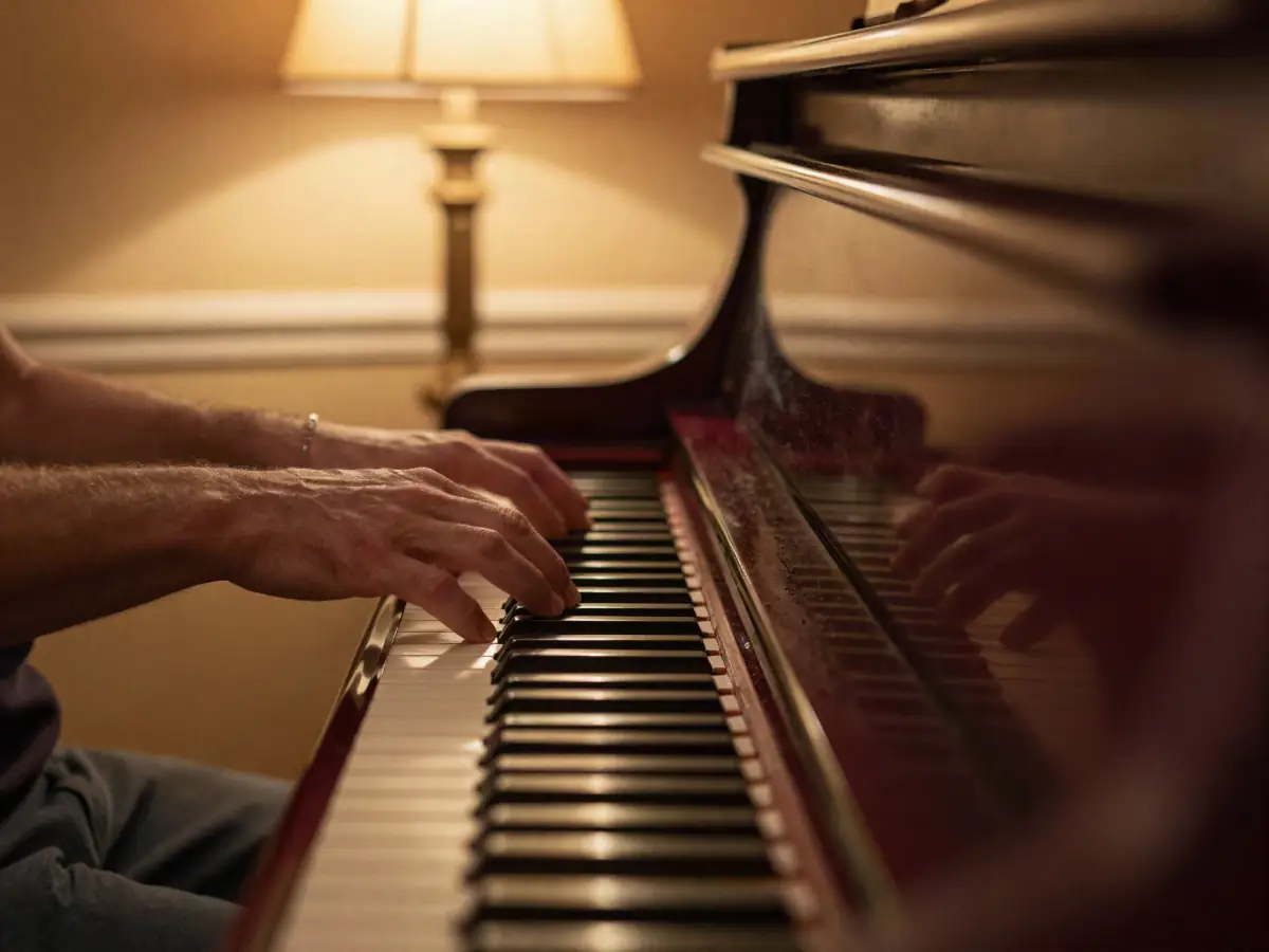 Relaxed hands playing a jazz chord on a grand piano