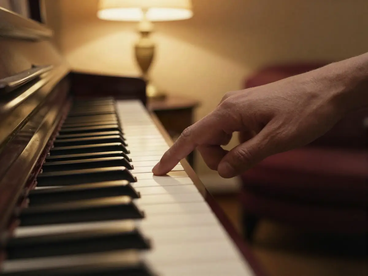 A finger pointing to middle C on a piano keyboard
