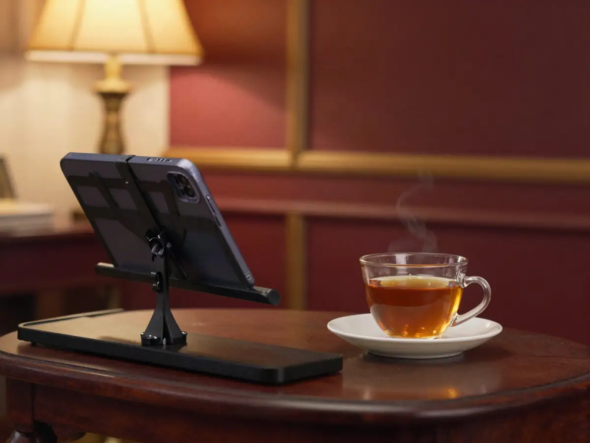 Smartphone propped on a keyboard music stand next to a cup of tea